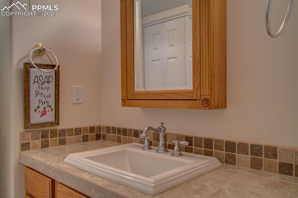 648 South McCulloch Boulevard Pueblo, CO 81007 - Photo 29 of 50 a bathroom with a granite countertop sink and a mirror