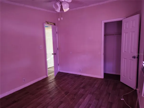 a view of empty room with wooden floor and a window