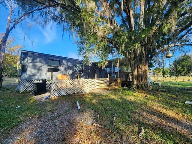a view of a house with backyard and sitting area