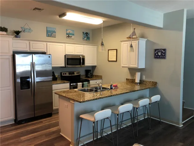 a kitchen with a refrigerator and a sink