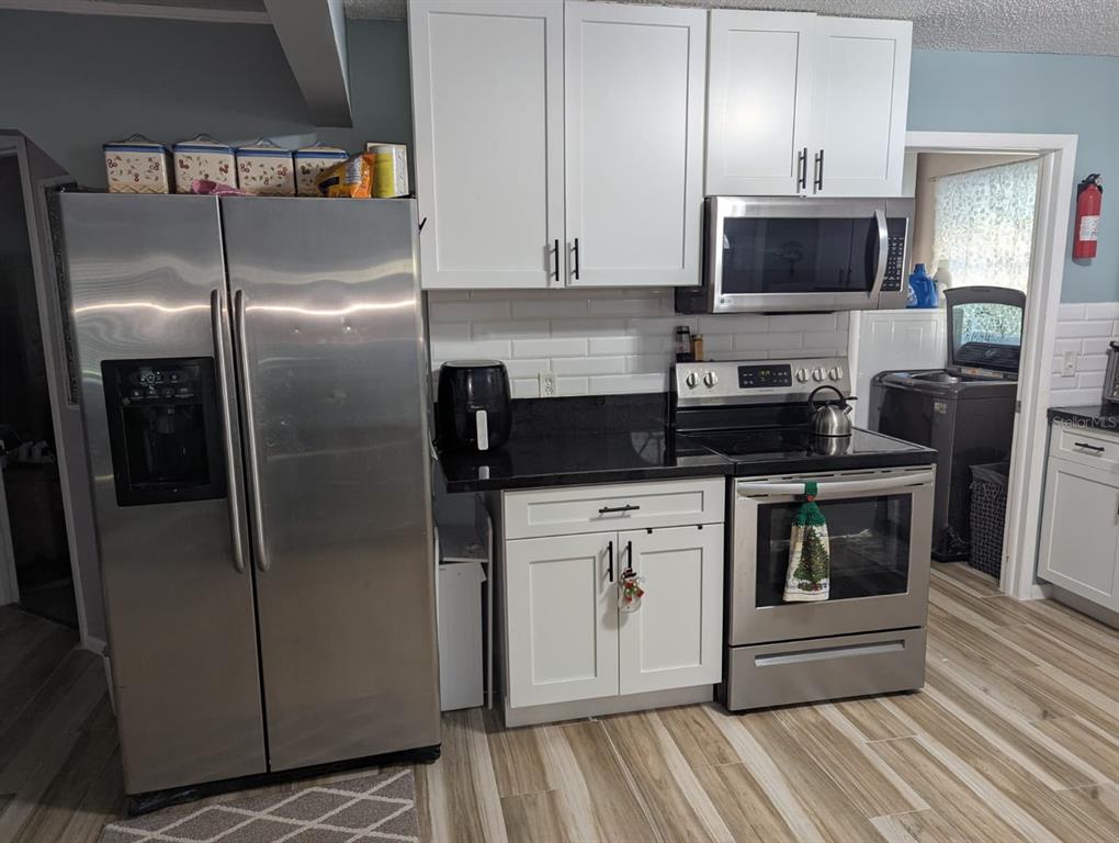 1692 West Salinas Road Avon Park, FL 33825 - Photo 5 of 13 a kitchen with stainless steel appliances a refrigerator a stove a microwave and cabinets