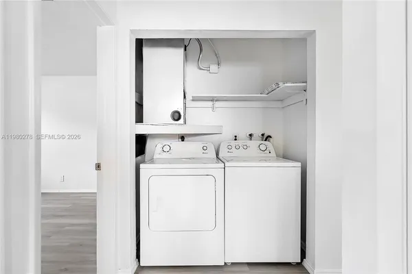 a white house that has a tree in front of it