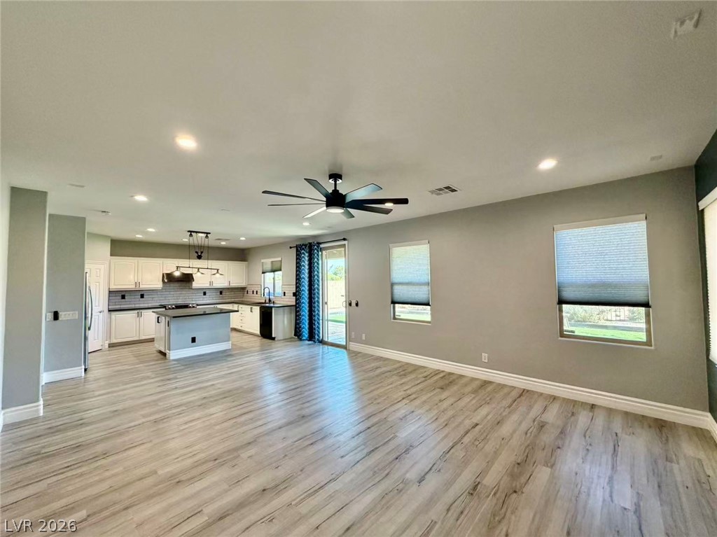 135 Tall Ruff Drive Las Vegas, NV 89148 - Photo 4 of 29 An open-concept living area boasts contemporary wood-look flooring and a functional kitchen space.