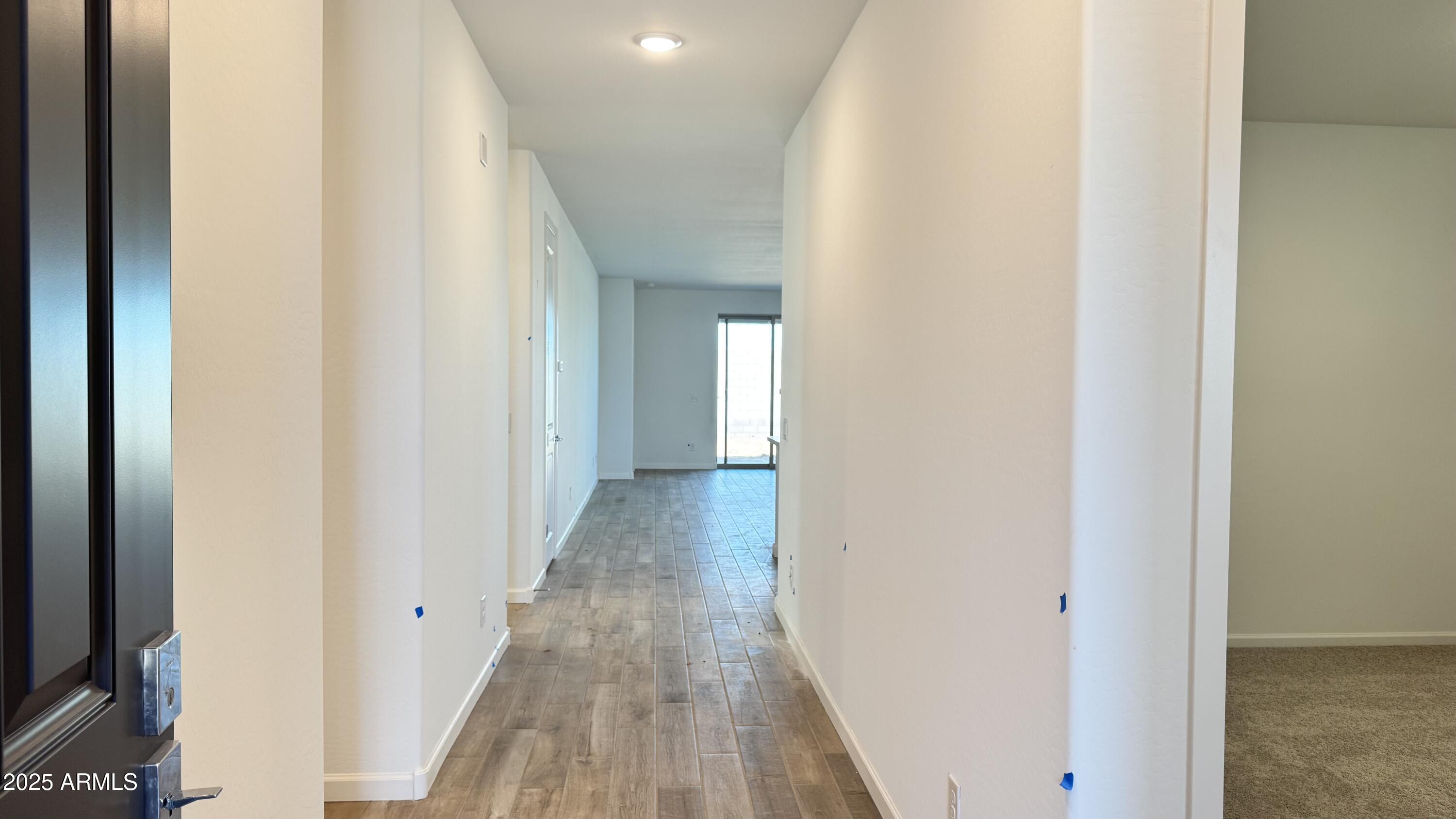 15748 West Camden Avenue Waddell, AZ 85355 - Photo 3 of 36 a view of a hallway with wooden floor