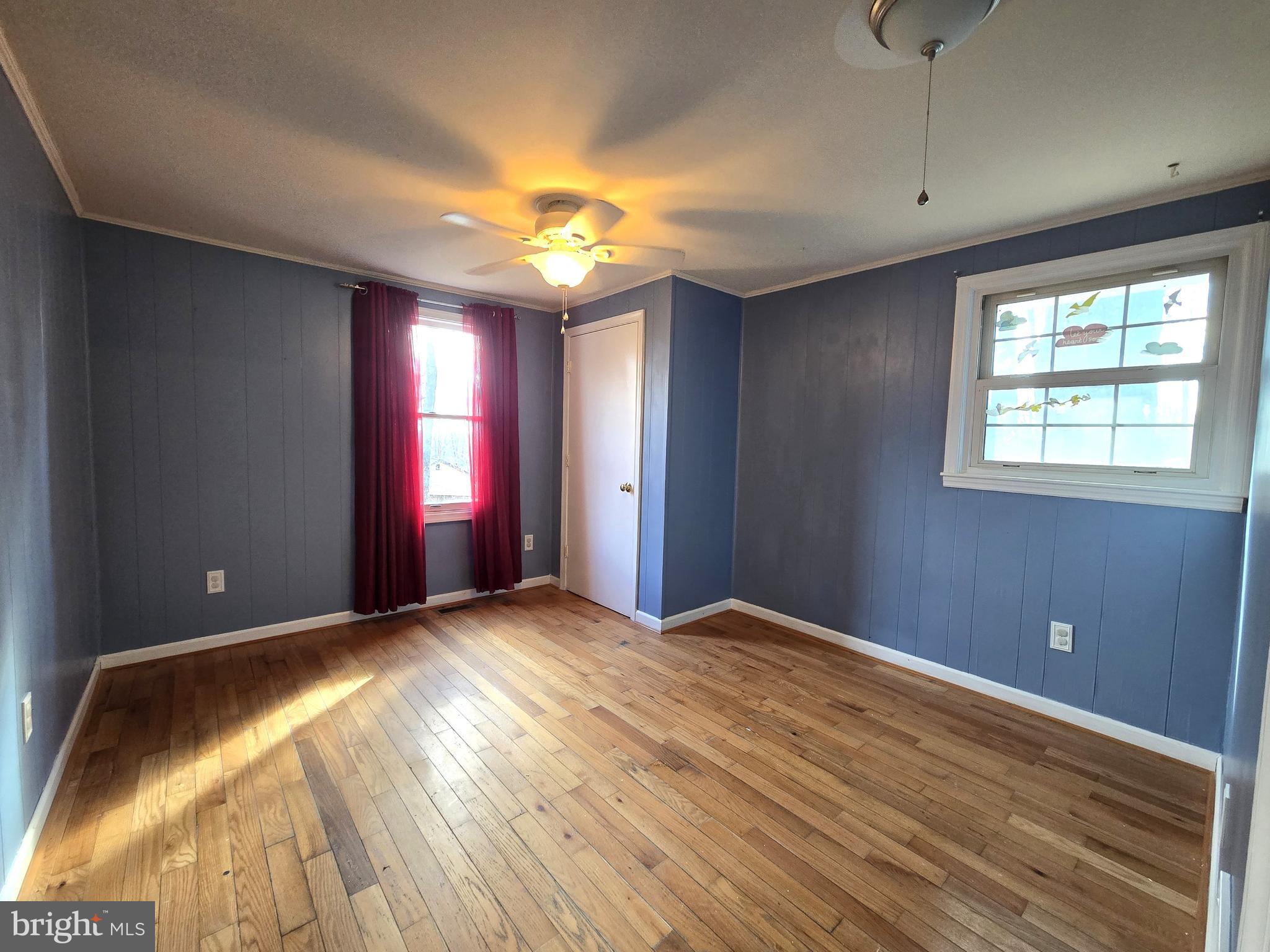 803 Tomahawk Trail Winchester, VA 22602 - Photo 14 of 20 a view of an empty room with window and wooden floor