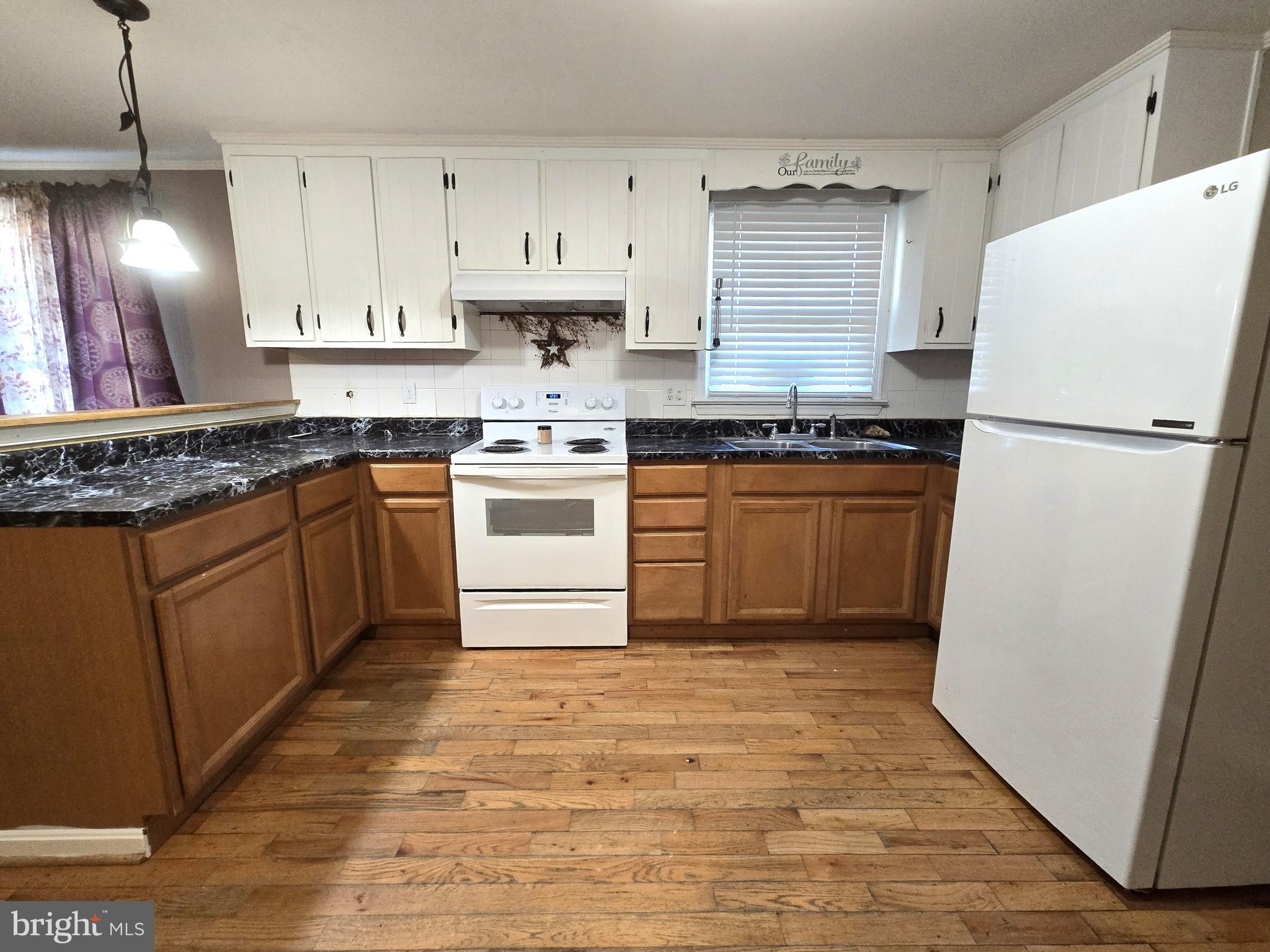 803 Tomahawk Trail Winchester, VA 22602 - Photo 7 of 20 a kitchen with granite countertop a white refrigerator a sink a stove and white cabinets