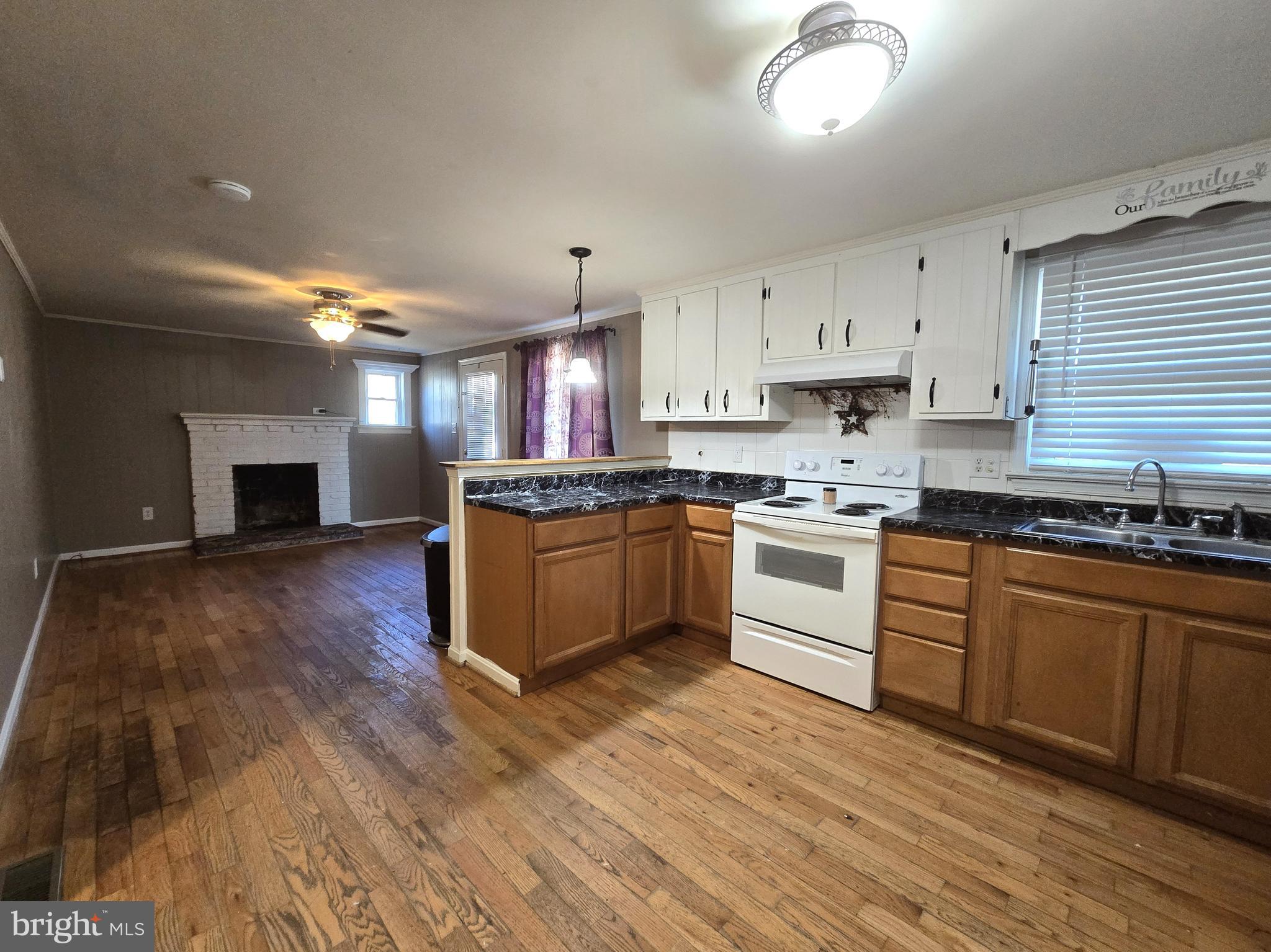 803 Tomahawk Trail Winchester, VA 22602 - Photo 8 of 20 a kitchen with granite countertop a stove top oven a sink dishwasher and a refrigerator with wooden floor
