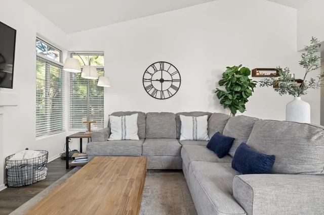 a living room with furniture a flat screen tv and a fireplace