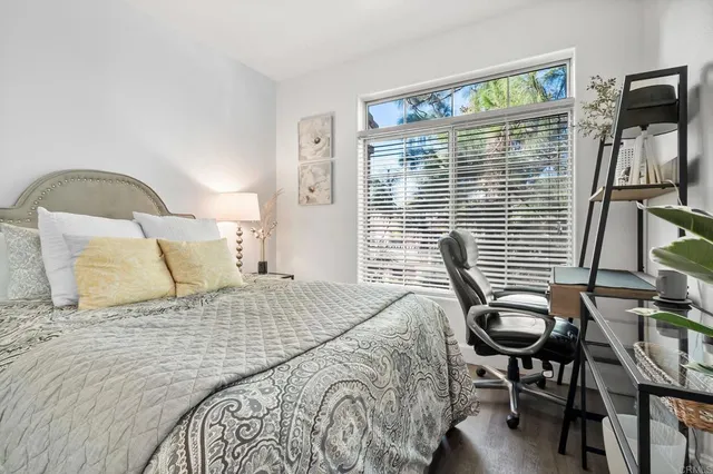 a bedroom with a bed and a desk next to a window