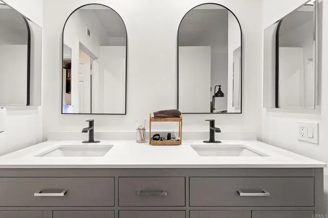 a en suite bathroom with a double vanity sink and a mirror
