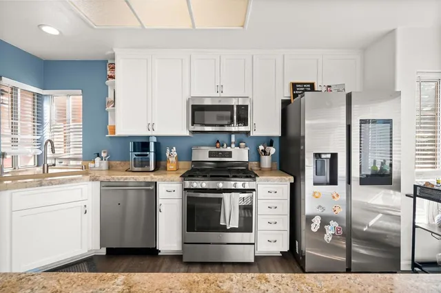 a kitchen with stainless steel appliances granite countertop a stove a refrigerator and a microwave