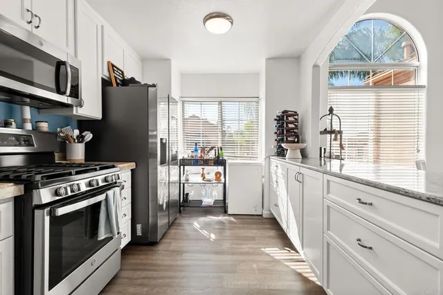 a kitchen with stainless steel appliances granite countertop a stove a refrigerator and a cabinets