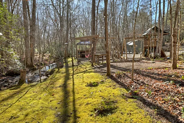 a view of a swimming pool with a bench and trees