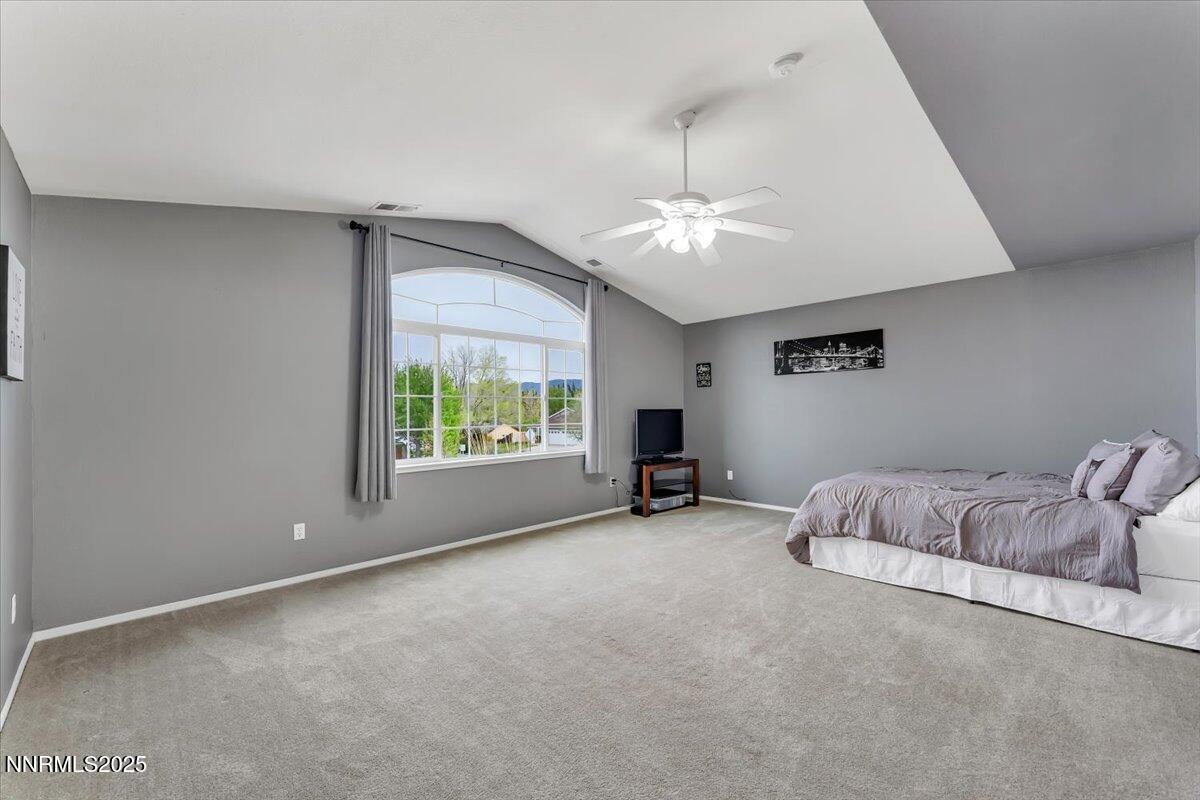 55 Ghost Rider Court Reno, NV 89511 - Photo 18 of 29 a spacious bedroom with a bed and a chandelier