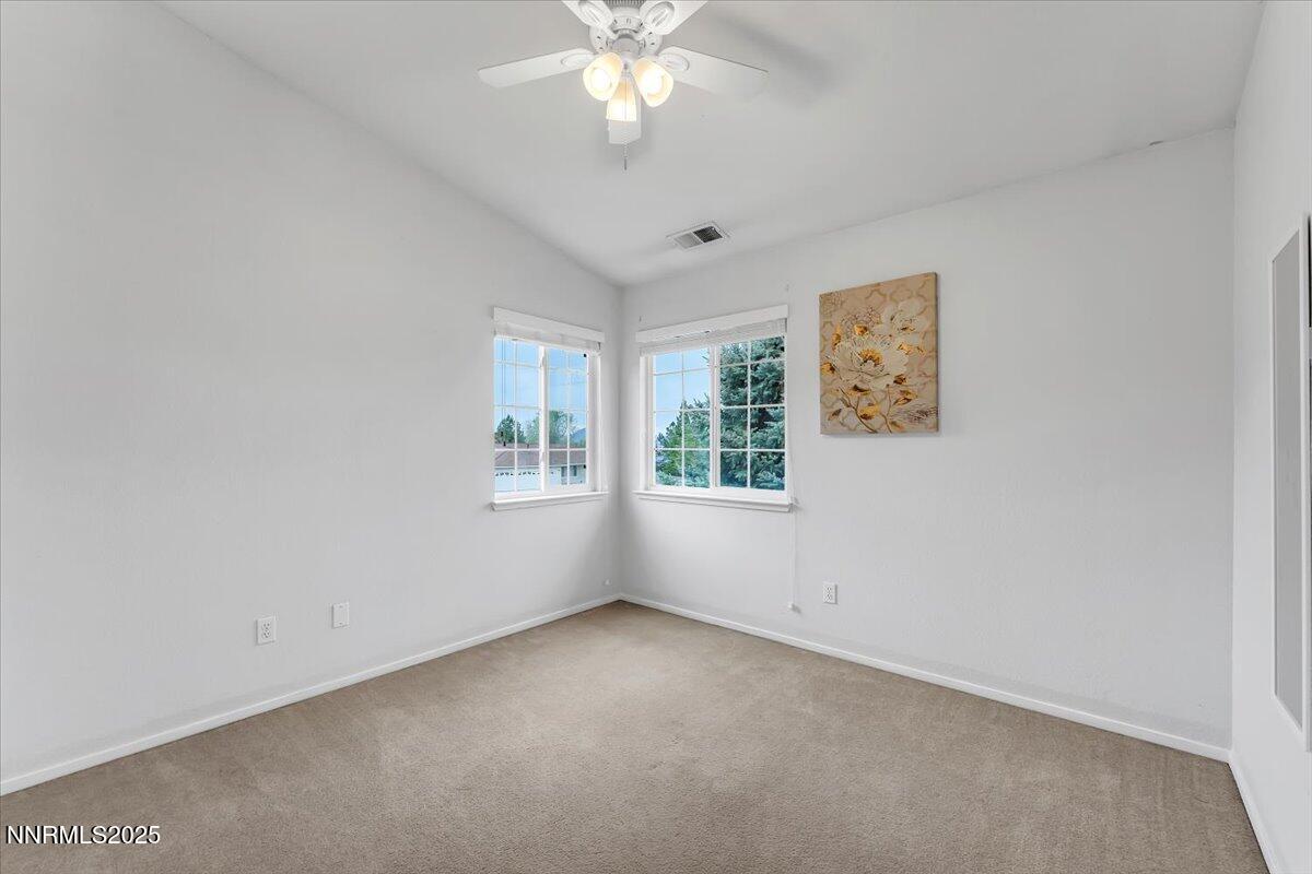 55 Ghost Rider Court Reno, NV 89511 - Photo 19 of 29 an empty room with windows and chandelier fan