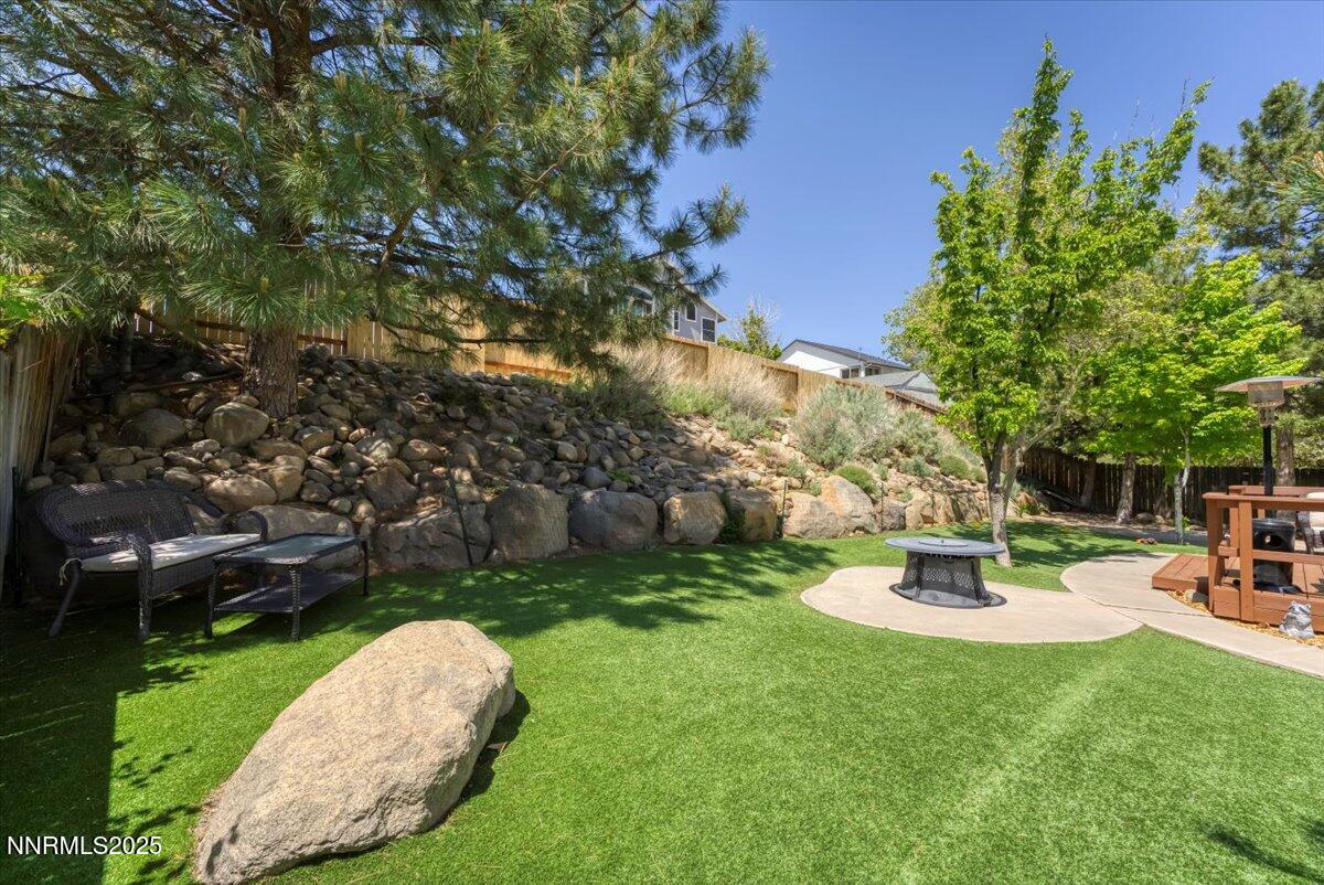 55 Ghost Rider Court Reno, NV 89511 - Photo 23 of 29 a view of a backyard with table and chairs and a large tree