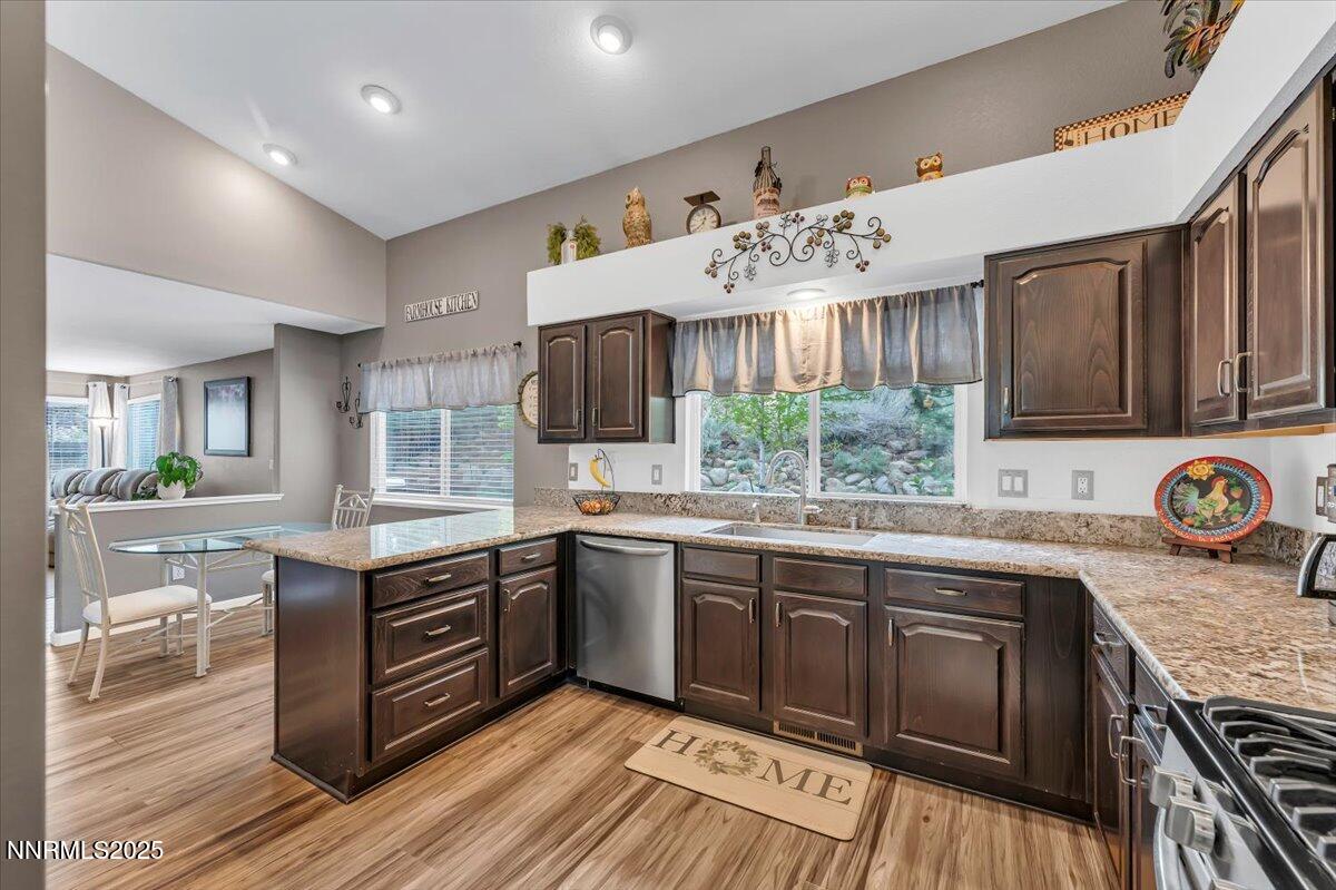 55 Ghost Rider Court Reno, NV 89511 - Photo 8 of 29 a kitchen with stainless steel appliances granite countertop wooden cabinets a sink dishwasher and a stove with wooden floor
