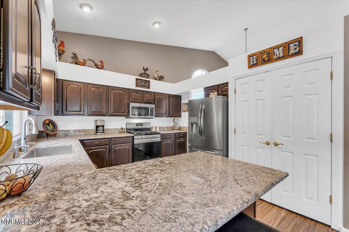 55 Ghost Rider Court Reno, NV 89511 - Photo 10 of 29 a kitchen with stainless steel appliances granite countertop a sink refrigerator and cabinets