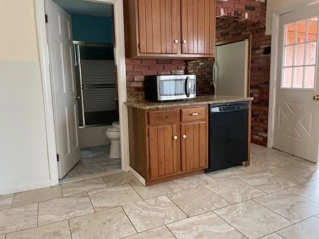a kitchen with stainless steel appliances granite countertop a refrigerator and a stove