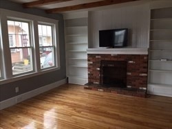 259 Massasoit Road Worcester, MA 01604 - Photo 7 of 23 a view of an empty room with wooden floor and a fireplace