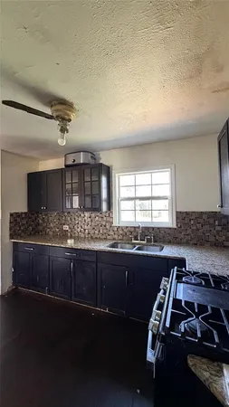 a kitchen with sink a stove and chairs