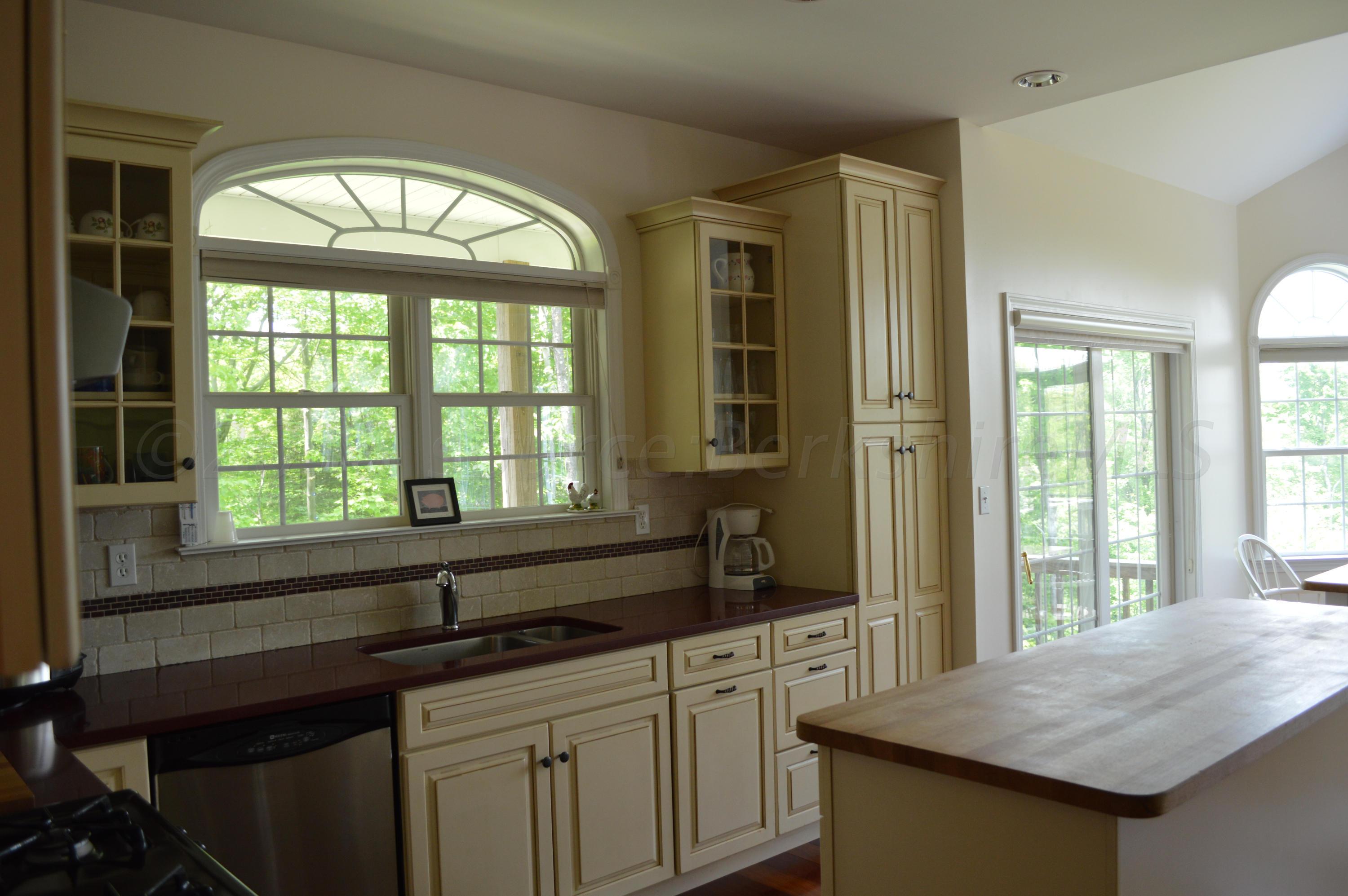 269 Skyline Ridge Road Becket, MA 01223 - Photo 11 of 42 a kitchen with a stove a sink and a wooden cabinets