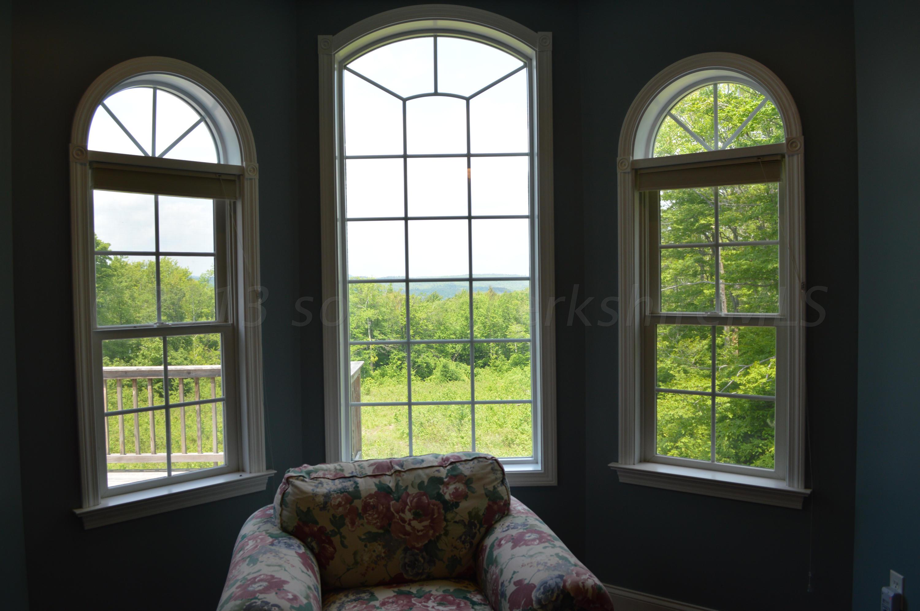 269 Skyline Ridge Road Becket, MA 01223 - Photo 16 of 42 a living room with a large window and a chandelier