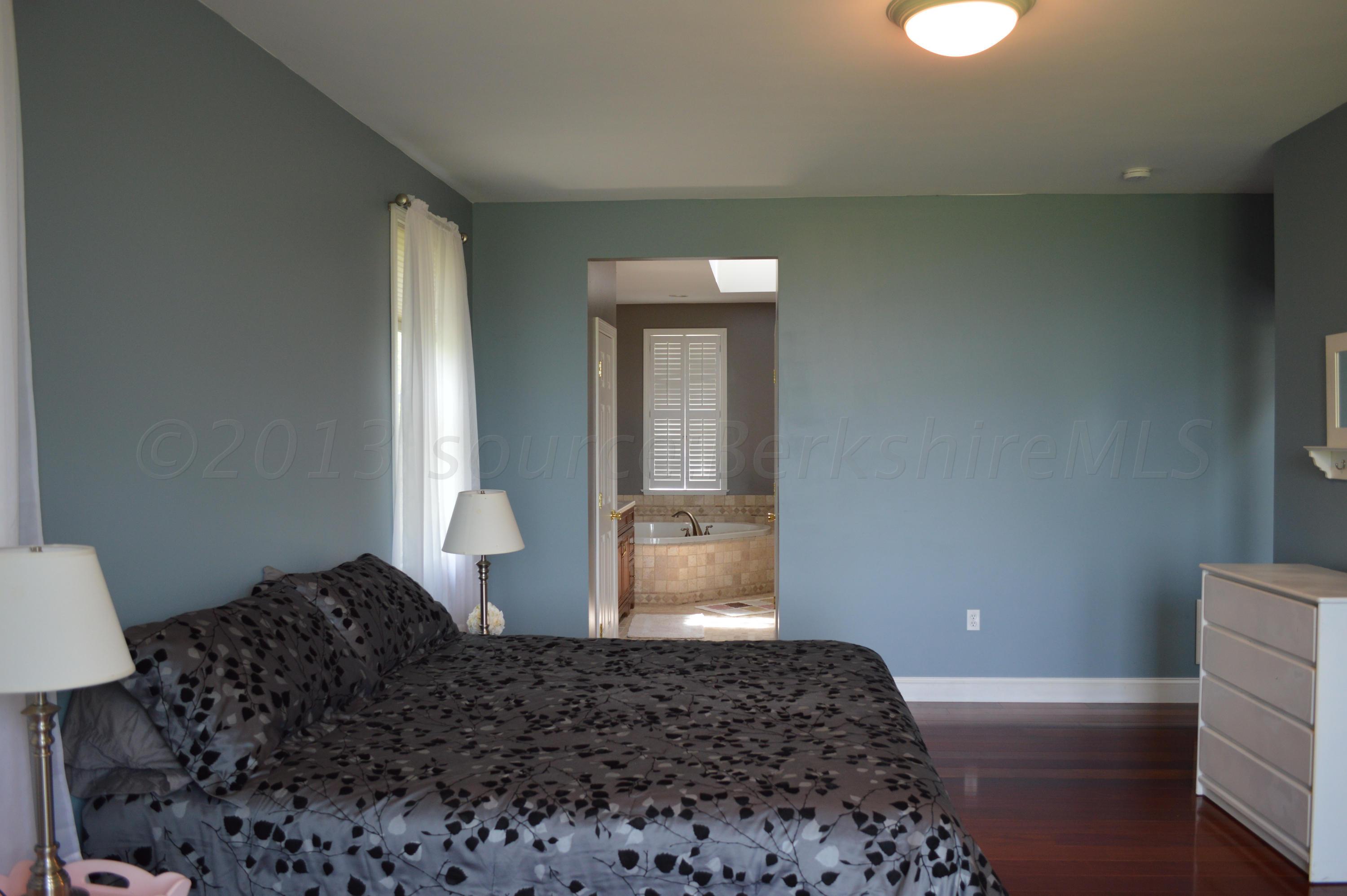 269 Skyline Ridge Road Becket, MA 01223 - Photo 17 of 42 a bedroom with a bed and wooden floor