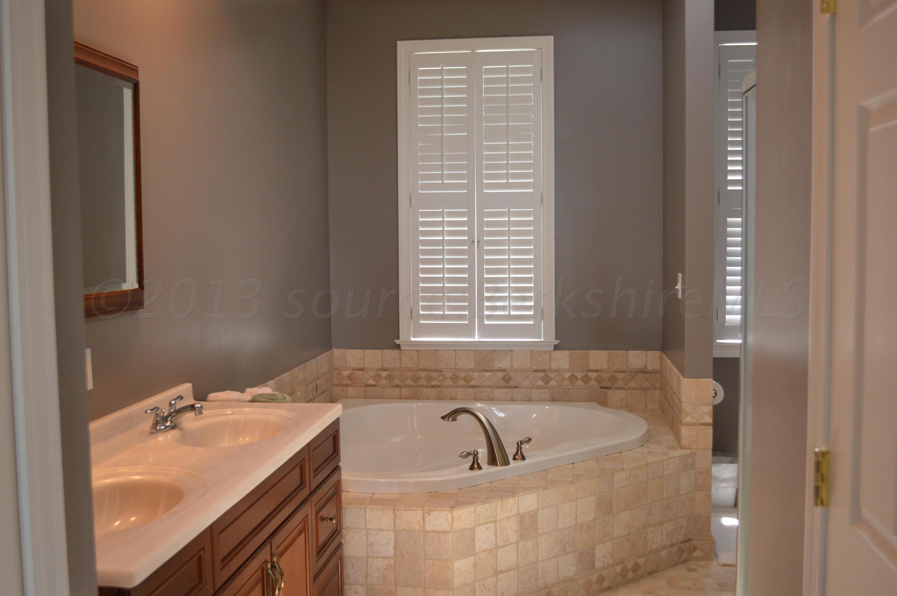 269 Skyline Ridge Road Becket, MA 01223 - Photo 18 of 42 a bathroom with a tub sink and mirror