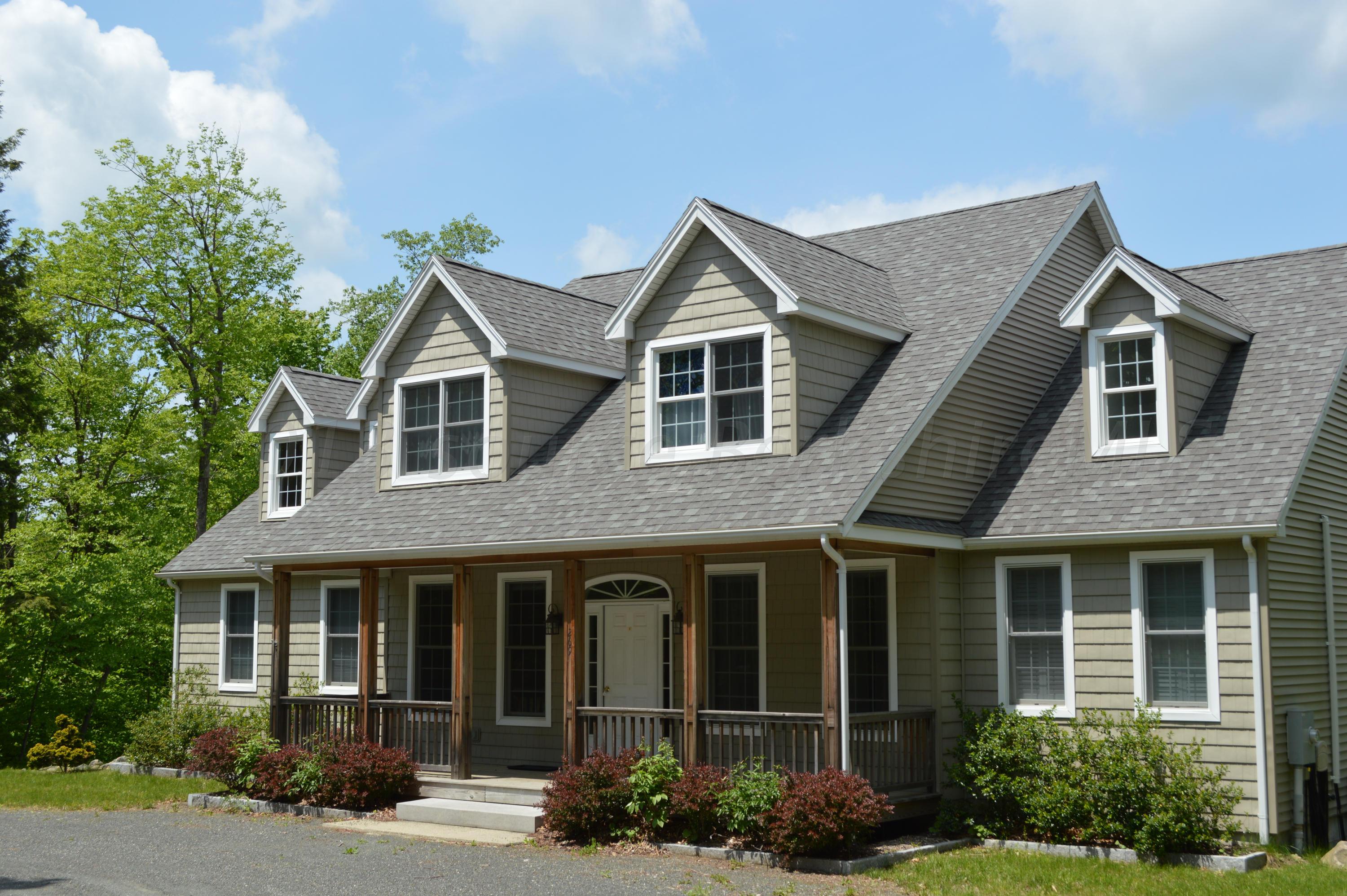 269 Skyline Ridge Road Becket, MA 01223 - Photo 34 of 42 a view of a brick house with large windows and flower plants
