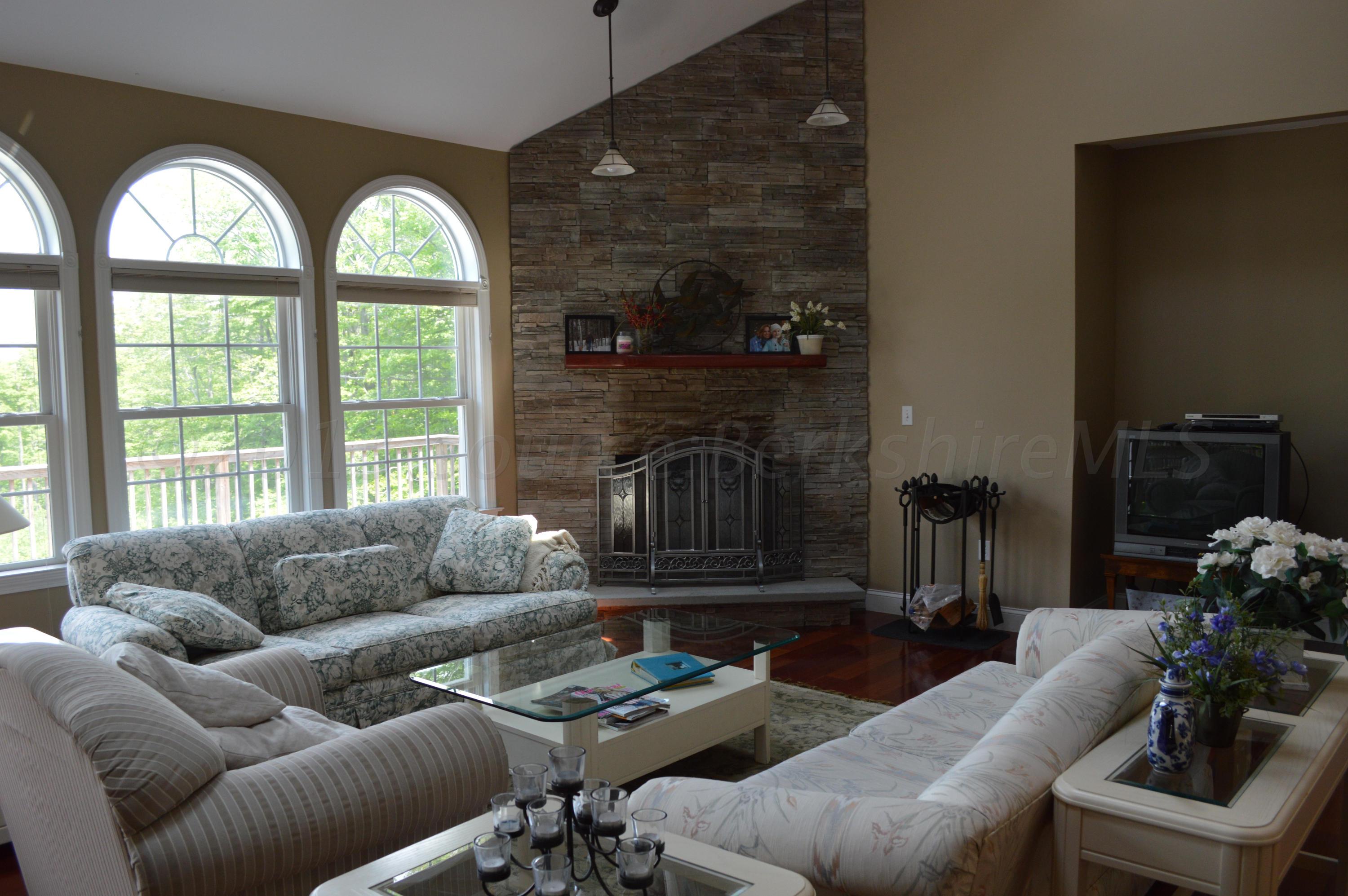 269 Skyline Ridge Road Becket, MA 01223 - Photo 7 of 42 a living room with furniture a fireplace and a large window