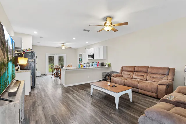 a living room with stainless steel appliances kitchen island granite countertop furniture and a refrigerator