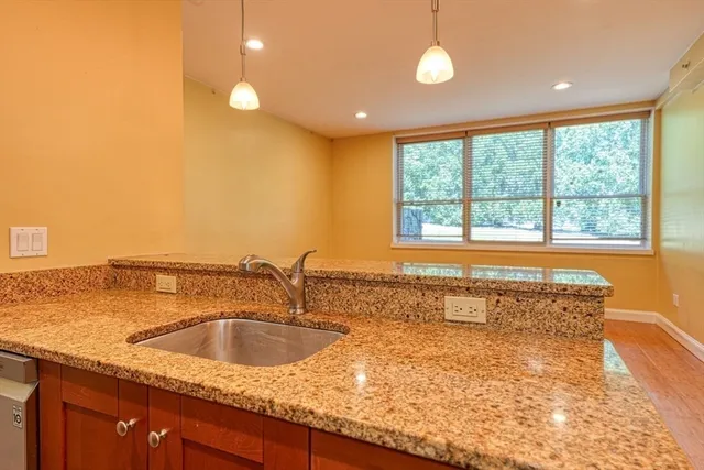 a bathroom with a granite countertop sink and large window