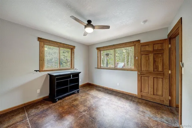 a view of empty room with windows and cabinet
