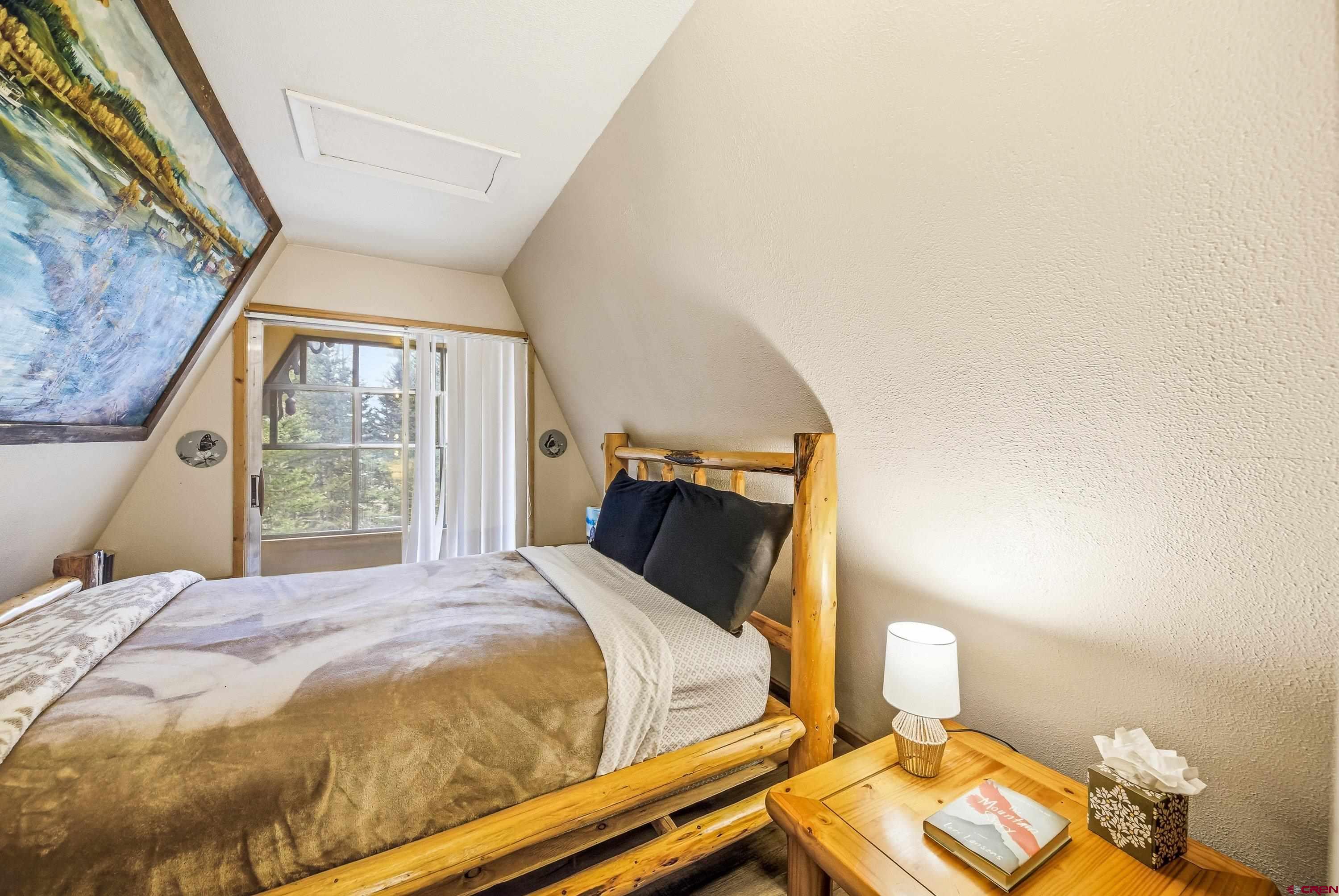 125 Aspen Trail Cimarron, CO 81220 - Photo 23 of 37 a bedroom with a bed and wooden floor