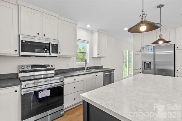 a kitchen with stainless steel appliances granite countertop a stove a microwave and cabinets