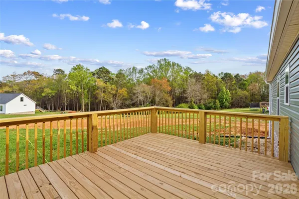 a view of a balcony with wooden floor and fence