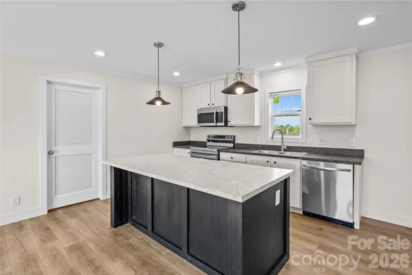 a kitchen with a sink a stove a microwave and cabinets