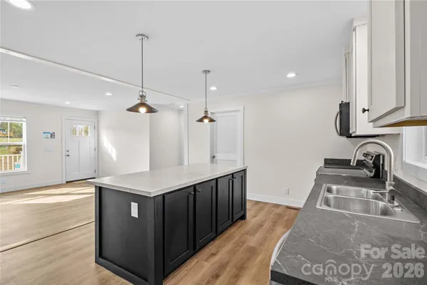 a kitchen with stainless steel appliances granite countertop a sink a stove and a wooden floors