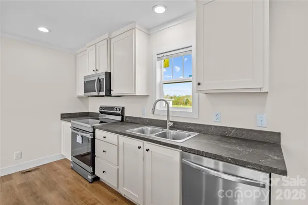 a kitchen with stainless steel appliances granite countertop a sink stove and cabinets