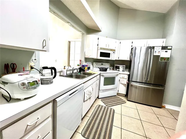 a kitchen with stainless steel appliances a sink a stove a refrigerator and cabinets