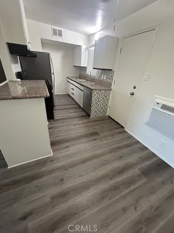 a utility room with wooden floor washer and dryer