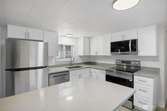 a kitchen with stainless steel appliances a refrigerator stove microwave and sink