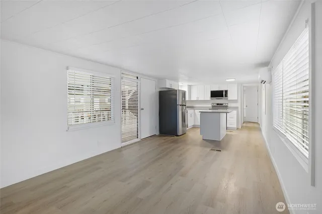 a view of a kitchen with a sink stove cabinets and empty room