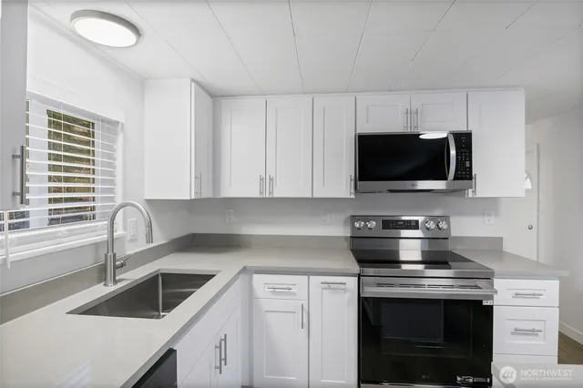 a kitchen with appliances a sink and a stove
