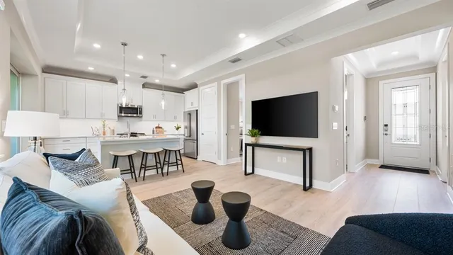 a kitchen with stainless steel appliances granite countertop a sink a stove a refrigerator and a dining table with wooden floor