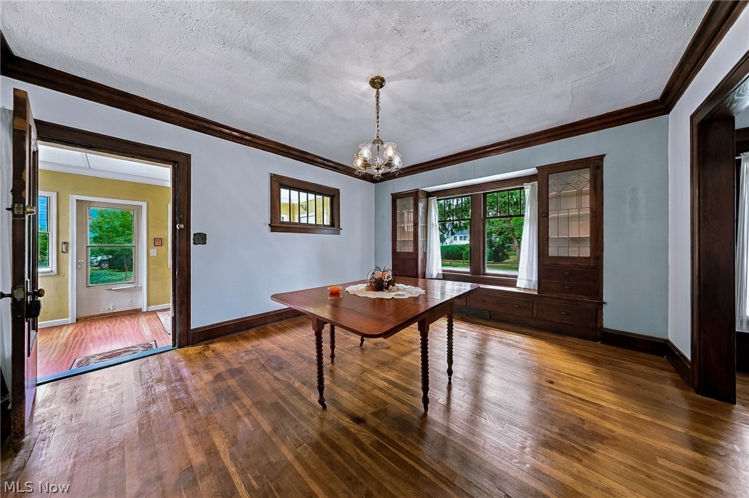 24958 Kennedy Ridge Road North Olmsted, OH 44070 - Photo 7 of 43 Hardwood flooring throughout, built-in cabinetry with glass doors, large bay window, and a chandelier lighting fixture