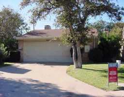 a front view of a house with a yard and tree