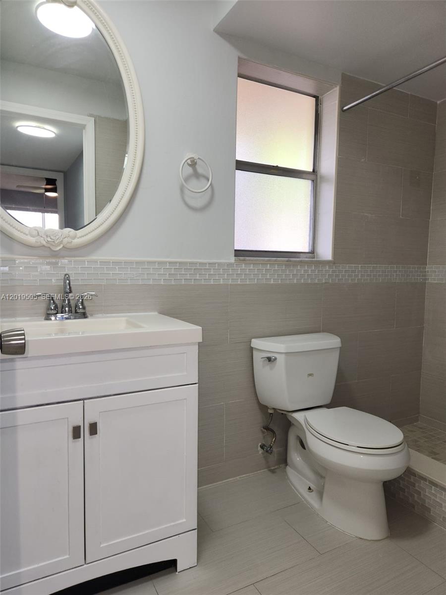 2811 North Pine Island Road, Unit 107 Sunrise, FL 33322 - Photo 8 of 16 a bathroom with a toilet sink and mirror