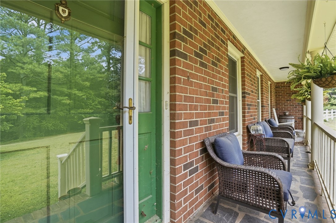 11016 Pridesville Road Amelia Court House, VA 23002 - Photo 5 of 54 Brick exterior featuring a covered porch with flag